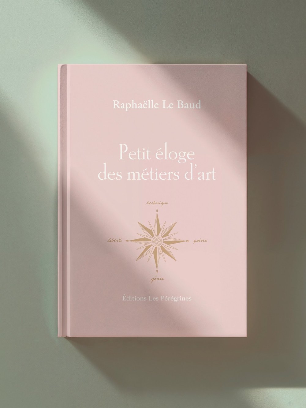 Le livre Petit éloge des métiers d'art, de Raphaëlle Le Baud, posé sur un fond vert sauge